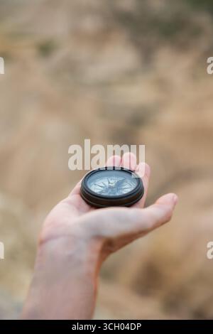 Close-up of hand holding compass in natural setting. Lifestyle. Hiking. Bardenas Reales. Stock Photo