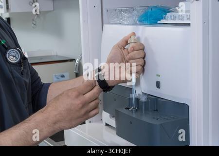 Medical technician using blood chemistry analyzing equipment in research lab, New York USA Stock Photo