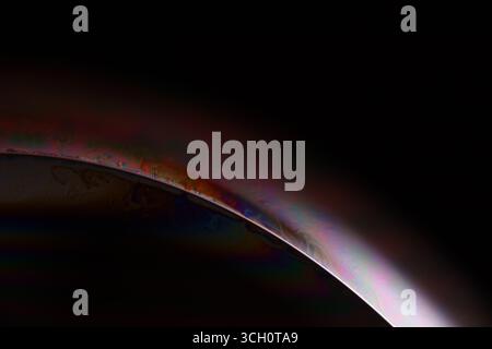 Macro Shot of a Soap Bubble Edge with Iridescent Rainbow Colors and Liquid Motion on Black Background Stock Photo