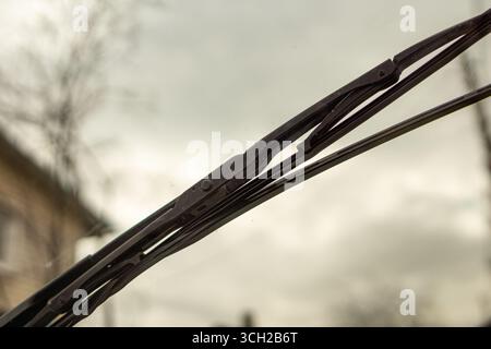 A worn-out wiper blade that leaves smears and streaks on the windshield, indicating it's time for a replacement on the damaged rubber , selective focu Stock Photo