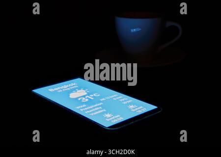 A smartphone displaying a glowing holographic user interface of a weather app. A concept for future technology, augmented reality (AR), data visualiza Stock Photo
