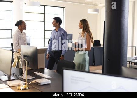 Business diverse professionals discussing project in modern office, engaging in conversation Stock Photo