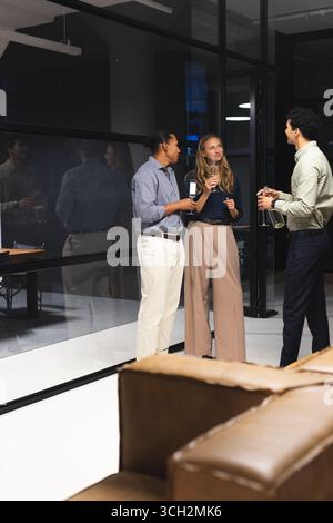 In office, diverse colleagues having drinks and conversation during evening gathering, copy space Stock Photo