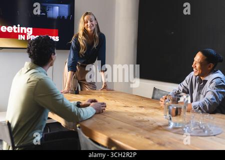 Business professionals discussing ideas during meeting in modern conference room Stock Photo