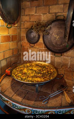 Traditional Valencian paella freshly made in a rustic kitchen. Stock Photo