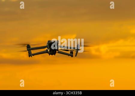 A drone in the sky at sunset Stock Photo