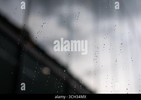 Rain drops on the glass window of the office building Stock Photo
