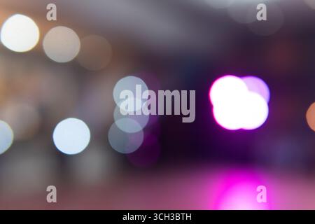 Abstract blurred bokeh background with colorful glowing circles in purple, white, and blue tones. Stock Photo