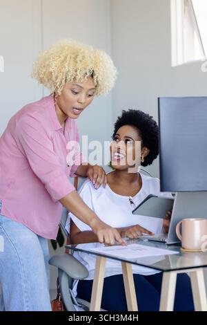 Colleagues collaborating on project at office, discussing ideas with enthusiasm Stock Photo