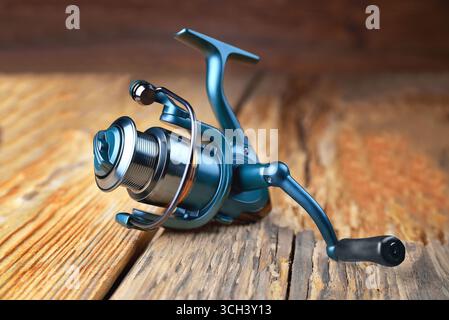 spinning reel lying on wooden rustic background close up selective focus Stock Photo