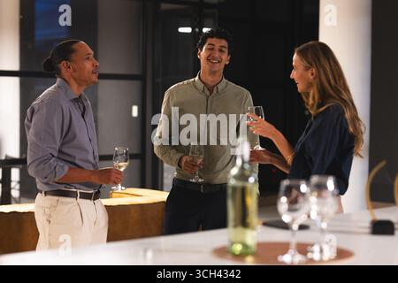 In office, colleagues having drinks and talking during evening gathering Stock Photo