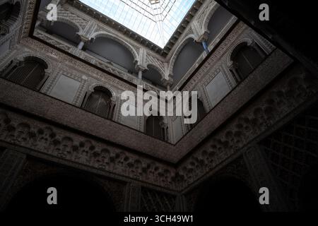 An intricate architectural interior featuring ornate carvings, multiple levels, and a skylight illuminating the space Stock Photo