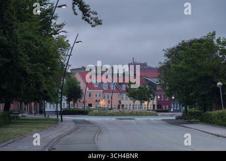 Picturesque street with colorful houses and lush trees in Thisted, Denmark. Urban greenery, residential architecture, and tranquil small-town Stock Photo