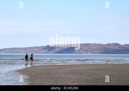 young couple walking along narin portnoo beach county donegal republic of ireland Stock Photo