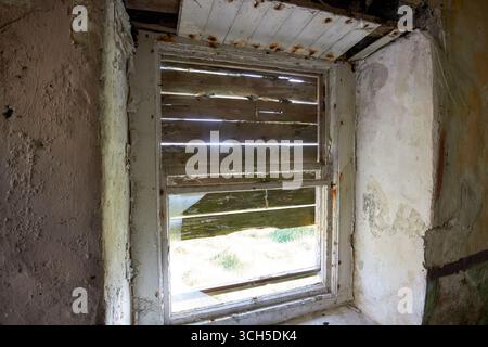 broken boarded up window in an old abandoned irish cottage on arranmore island county donegal republic of ireland Stock Photo