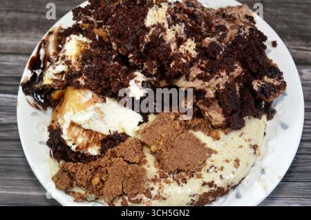 Plate of mixed desserts of Tiramisu ladyfinger pastries (Savoiardi) dipped in coffee, Dark chocolate spread profiterole cream puffs, filled French cho Stock Photo