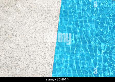 Edge of pool and blue pool water. Top view, copy space, design template. Stock Photo