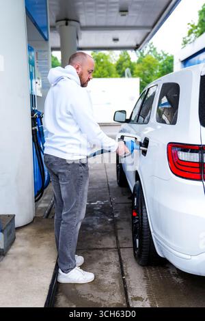 Man filling his SUV fuel tank at a petrol station in Dubai, United Arab ...