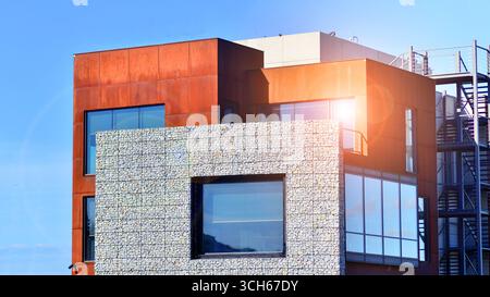 Office building facade covered in unique Corten steel, stones and glass materials. Stock Photo