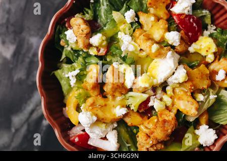 Caesar salad with chicken and dressing. Fresh lettuce with croutons and cheese. Tasty healthy meal in ceramic bowl. Nutritious diet lunch. Stock Photo
