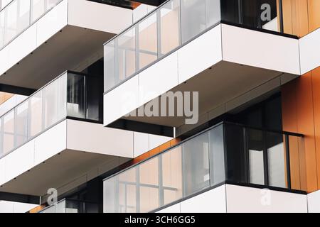 Modern apartment building facade with balconies. Contemporary architecture design. Urban housing development detail. Glass and metal structure. Stock Photo