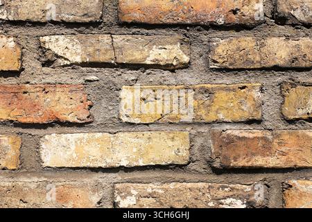 Old brick wall texture background. Rustic surface detail with weathered stone bricks. Vintage construction material pattern. Stock Photo