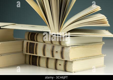 Books from several volumes in one stack on the table for school. of a book for school. Stock Photo