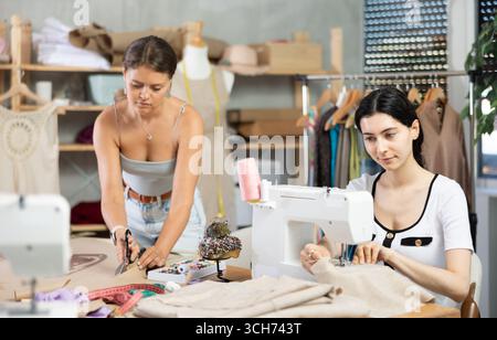 Two female tailors working on custom garment in studio Stock Photo