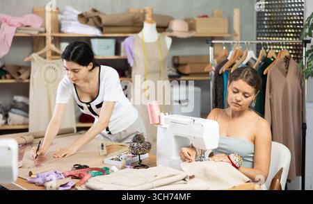 Two female tailors working on custom garment in studio Stock Photo