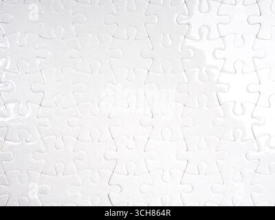 White jigsaw puzzle fully assembled with clean minimal look, representing completion, teamwork, integration, problem-solving, unity, and system connec Stock Photo