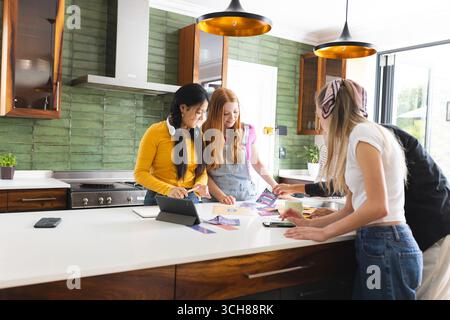 In modern kitchen, teen friends collaborating on creative project, sharing ideas enthusiastically Stock Photo