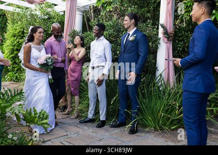 Joyful groom in blue suit and bride in white wedding dress embracing while  smiling and kissing on evening with Eiffel Tower on background at Paris  Stock Photo - Alamy