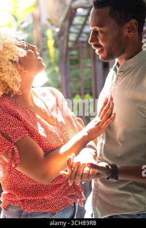 Friends enjoying sunny day outdoors, smiling and engaging in lively conversation Stock Photo
