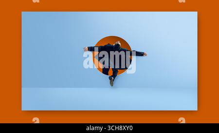 Digital artwork. Businessman jumping through round doorway on blue wall with open arms and dramatic fashion expression Stock Photo