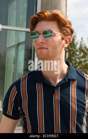 Summer afternoon in the city with a young man wearing sunglasses Stock Photo