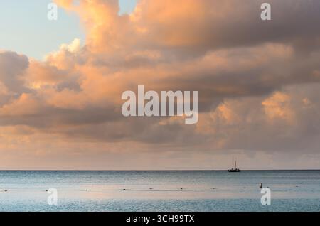 Sailboat at Sunset with Vibrant Clouds in Aruba Stock Photo