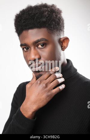 Portrait of pensive man looking at the camera, touching his chin Stock Photo