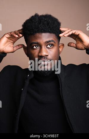 Close-up of African elegant man in black jacket posing at camera Stock Photo