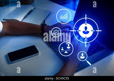 Hands typing on a laptop with digital icons symbolizing data analytics and communication displayed on the screen at night Stock Photo