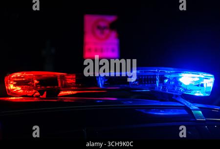 a flashing beacon on the top of a chinese police car is shown in action Stock Photo