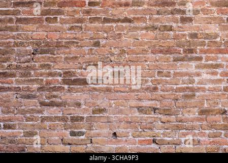Close-up of ancient stone wall with irregular blocks and earthy colors, showcasing rustic texture for backgrounds, design, or historical architectural Stock Photo