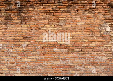 Close-up of ancient brick wall with rough surface and earthy colors, highlighting historic architectural detail Stock Photo