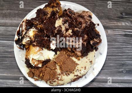 Plate of mixed desserts of Tiramisu ladyfinger pastries (Savoiardi) dipped in coffee, Dark chocolate spread profiterole cream puffs, filled French cho Stock Photo