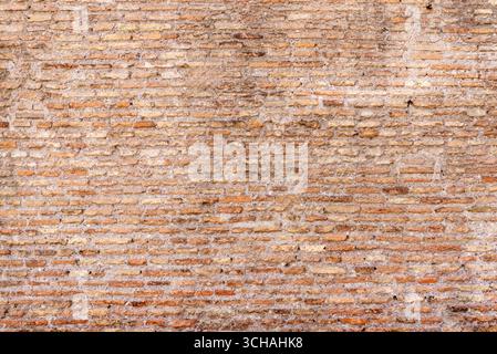 Detailed texture of an aged brick wall with earthy tones and worn-out surface Stock Photo