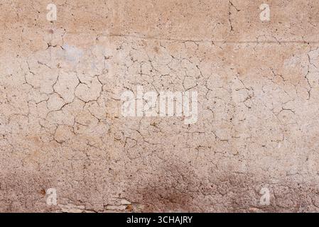 Close-up of cracked plaster wall surface with natural texture and rough details Stock Photo