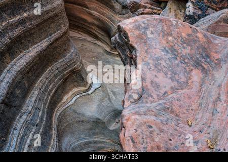 Textures and patterns of the red sandstone of a faux slot canyon in the Clear Creek section of Zion National Park in Utah Stock Photo