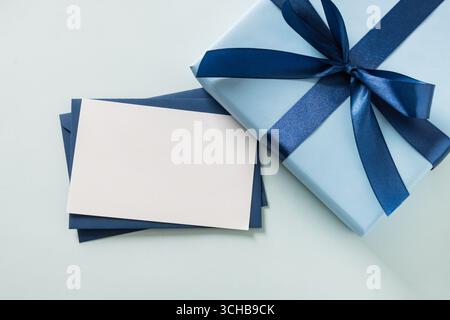 Blue gift box, envelope and empty blank on pastel blue background. Flat lay. View from above. Copy space. Happy Fathers Day Stock Photo