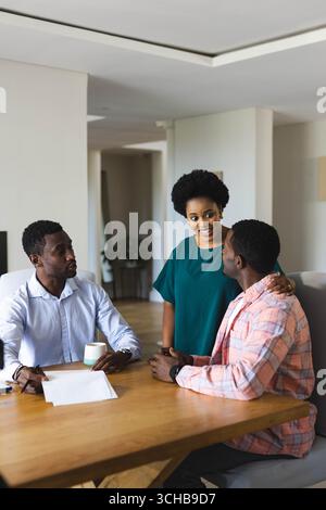 Reviewing documents African American colleagues at conference table in office, with papers and mug. Business, collaboration, workplace, modernity, pro Stock Photo