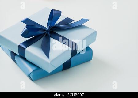 Two blue gift boxes for birthday on pastel blue background. Greeting card, flyer or invitation. Close up. Present for man. Stock Photo