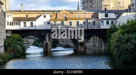 Historic Pulteney Bridge viewed from the rear with shops, spanning the River Avon in Bath, England, under a clear sky with reflections on the water Stock Photo